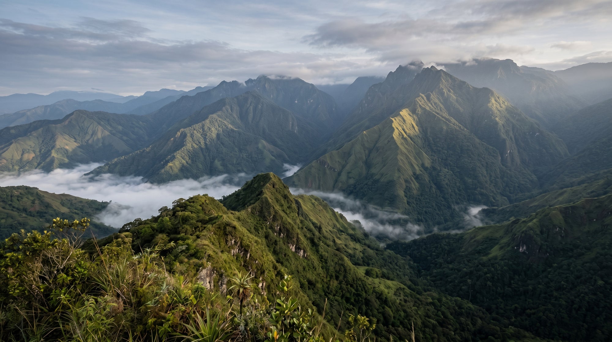Scenic view of mountain ranges with clouds at the valley